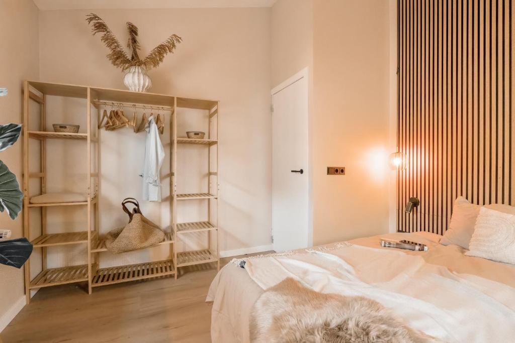 a bedroom with a bed and shelves in it at Mamooi Julianadorp in Julianadorp