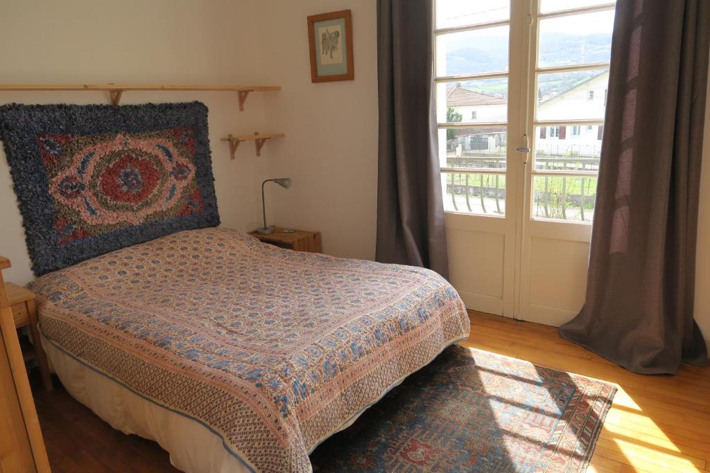 a bedroom with a bed and a large window at No.5 in Saint-Girons