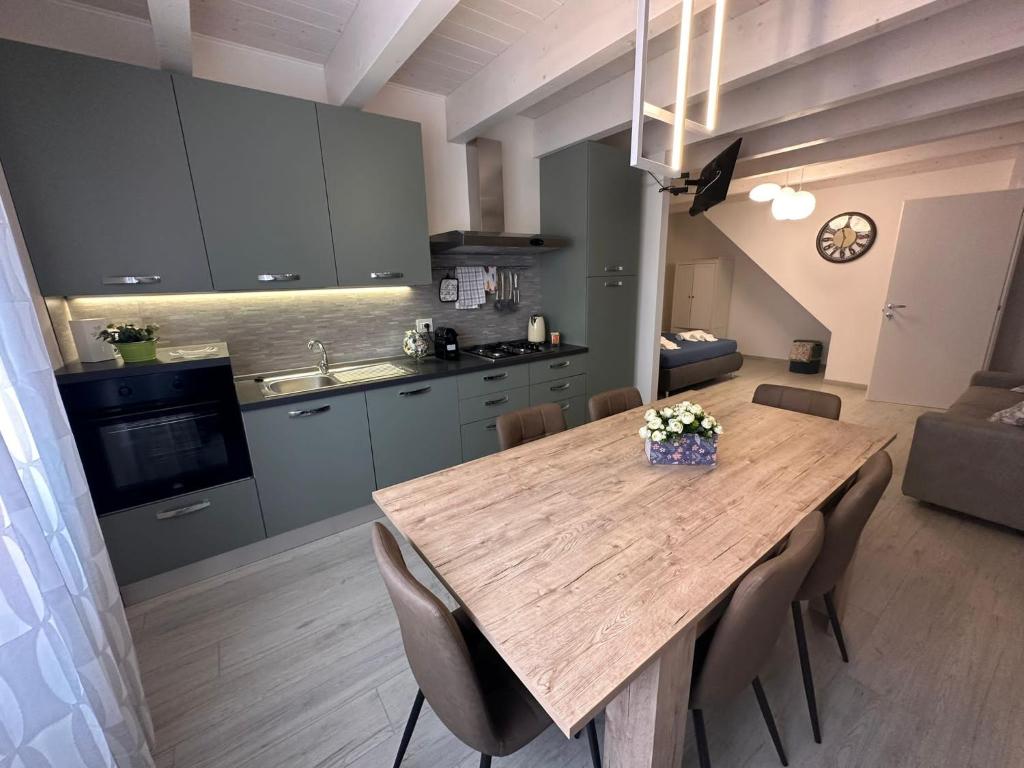 a kitchen and dining room with a wooden table and chairs at B&B La Fortezza in Comacchio