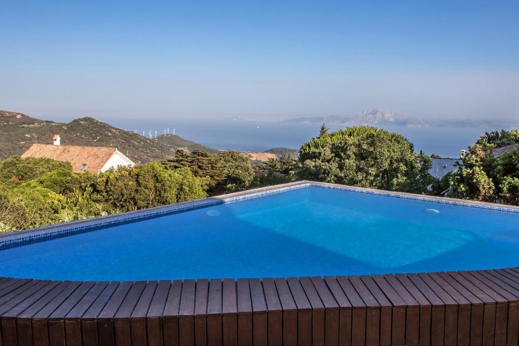 a large blue swimming pool on top of a house at Livingtarifa - Casa Los Helechos in El Bujeo