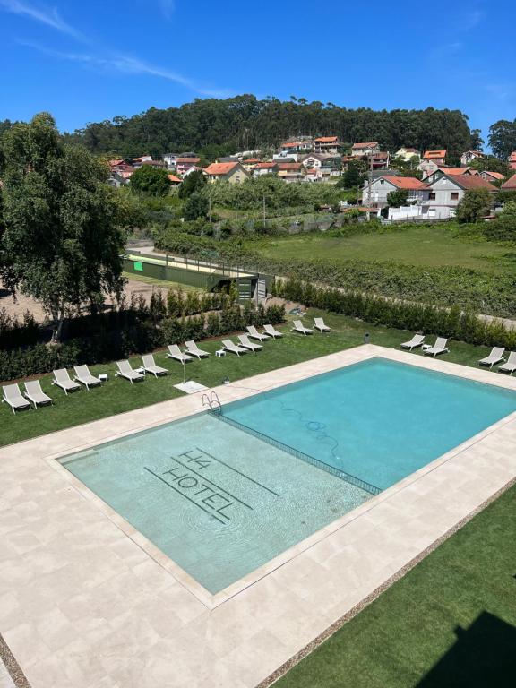 an overhead view of a swimming pool with lounge chairs at Hotel H4 Cangas 3 Superior in Cangas de Morrazo