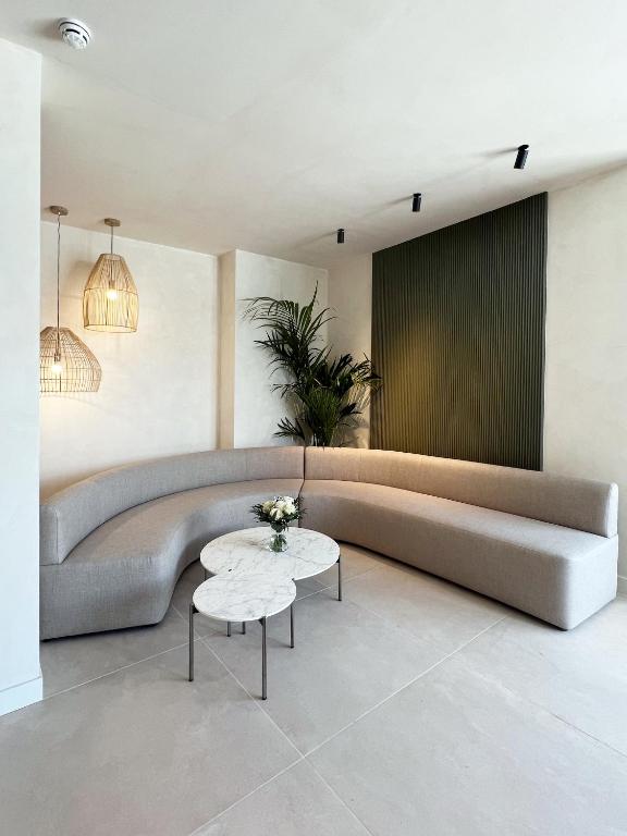 a living room with a large couch and a table at Hotel H4 Cangas 3 Superior in Cangas de Morrazo