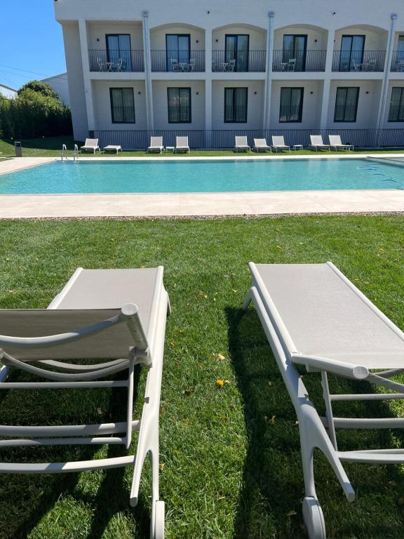a picnic table next to a swimming pool at Hotel H4 Cangas 3 Superior in Cangas de Morrazo