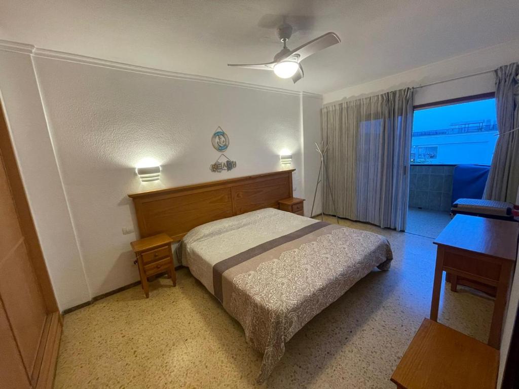 プラヤ・デル・イングレスにあるAgaete parque Playa del Inglésのベッドルーム1室(ベッド1台、デスク、窓付)