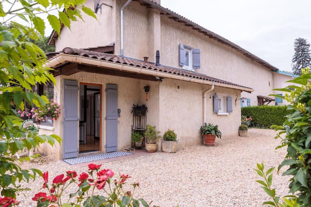 a house with a door and flowers in front of it at La maison du lac du Grobon in Châtillon-sur-Chalaronne
