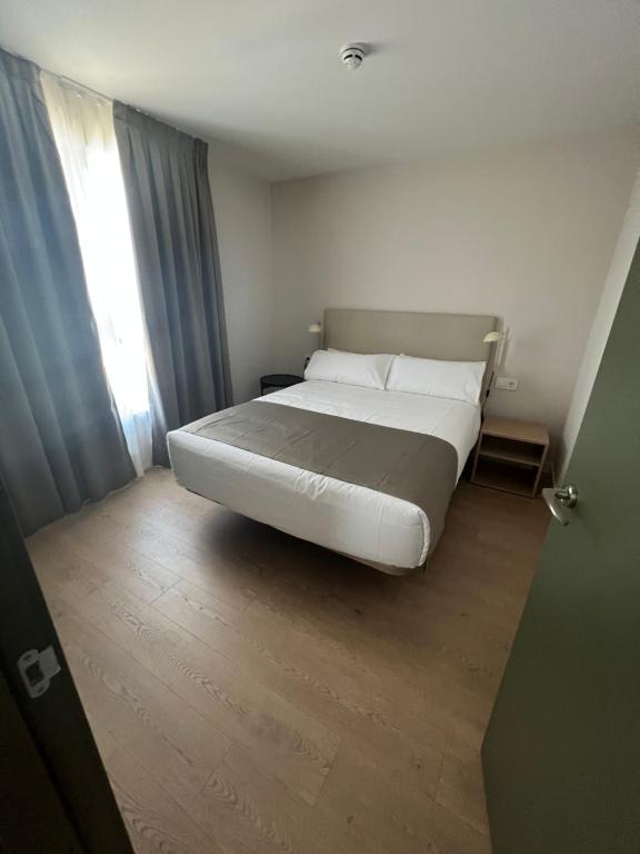 a bedroom with a large white bed and a window at Hotel H4 Cangas 3 Superior in Cangas de Morrazo