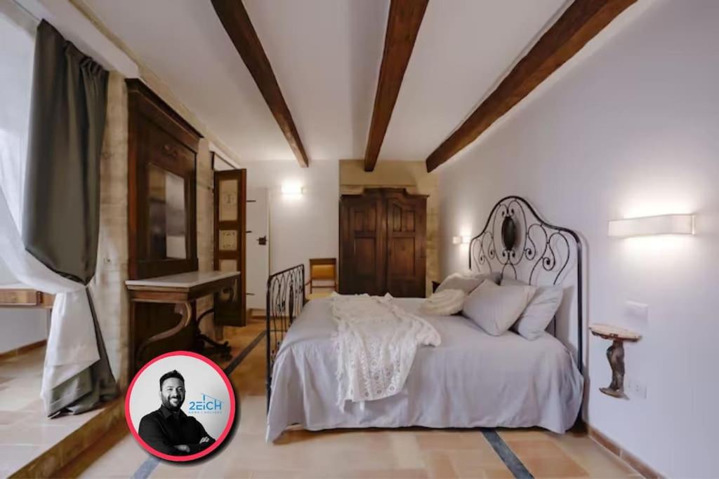 a bedroom with a bed with a picture of a man at [Luxury House] Palazzo Signorile in Centro in Civitanova Alta