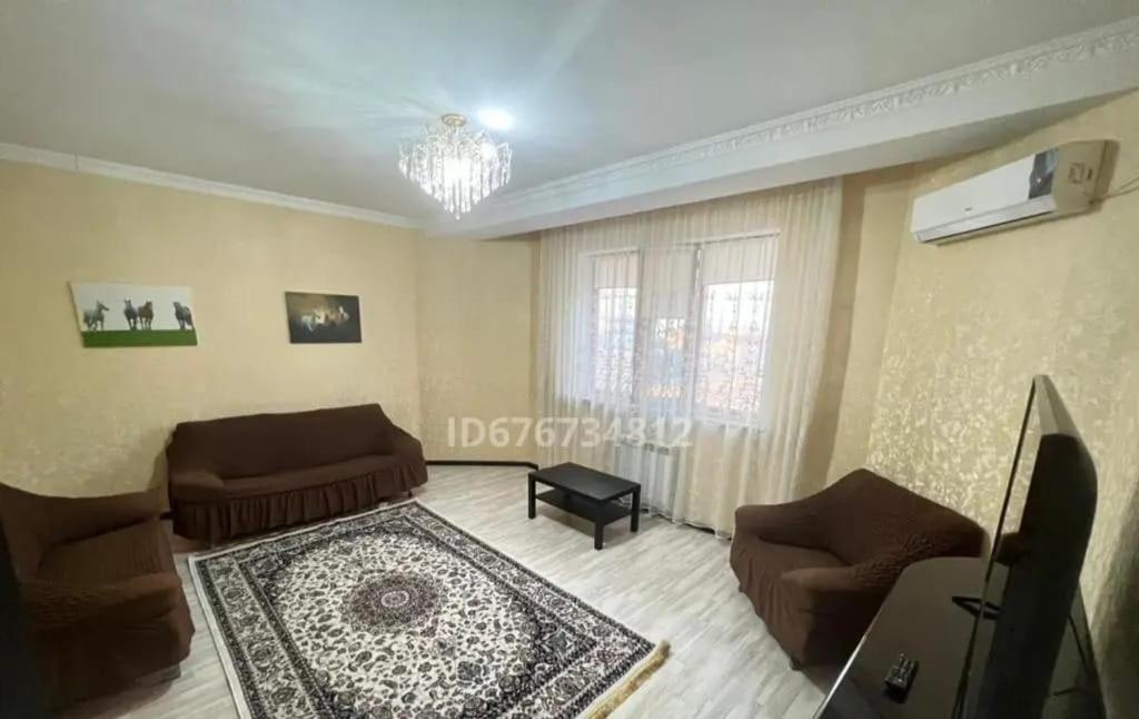 uma sala de estar com um sofá e uma mesa em ЖК Томирис 2 комнатная квартира em Atyraū