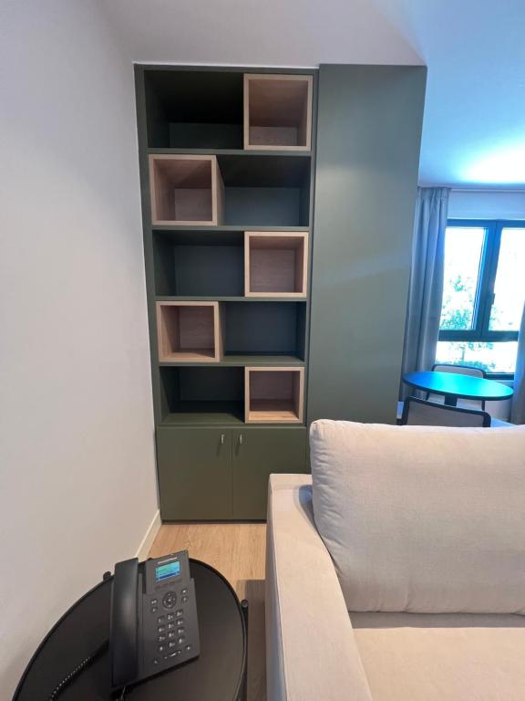 a room with a couch and a table with a remote control at Hotel H4 Cangas 3 Superior in Cangas de Morrazo
