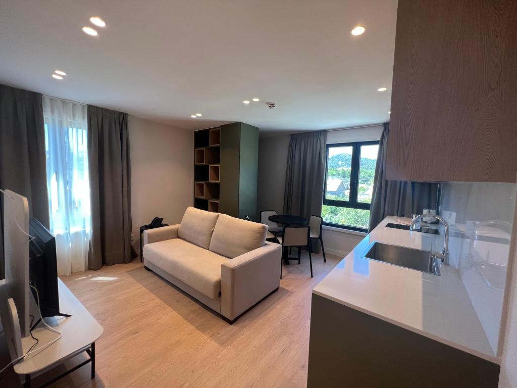 a kitchen and living room with a couch and a table at Hotel H4 Cangas 3 Superior in Cangas de Morrazo