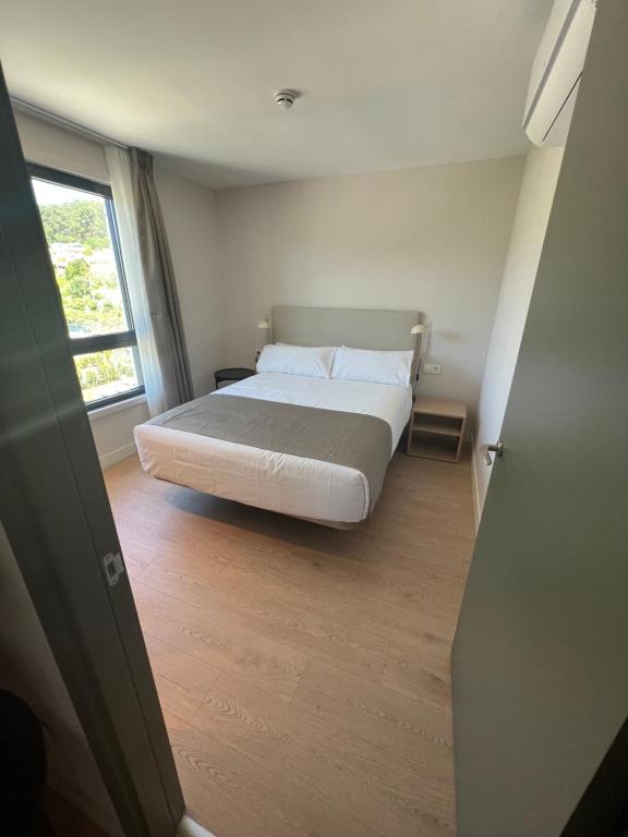 a bedroom with a bed and a window at Hotel H4 Cangas 3 Superior in Cangas de Morrazo