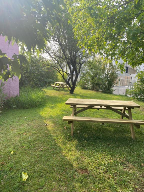 a wooden picnic table sitting in the grass at Kyriad Montpellier Aéroport - Gare Sud de France in Mauguio