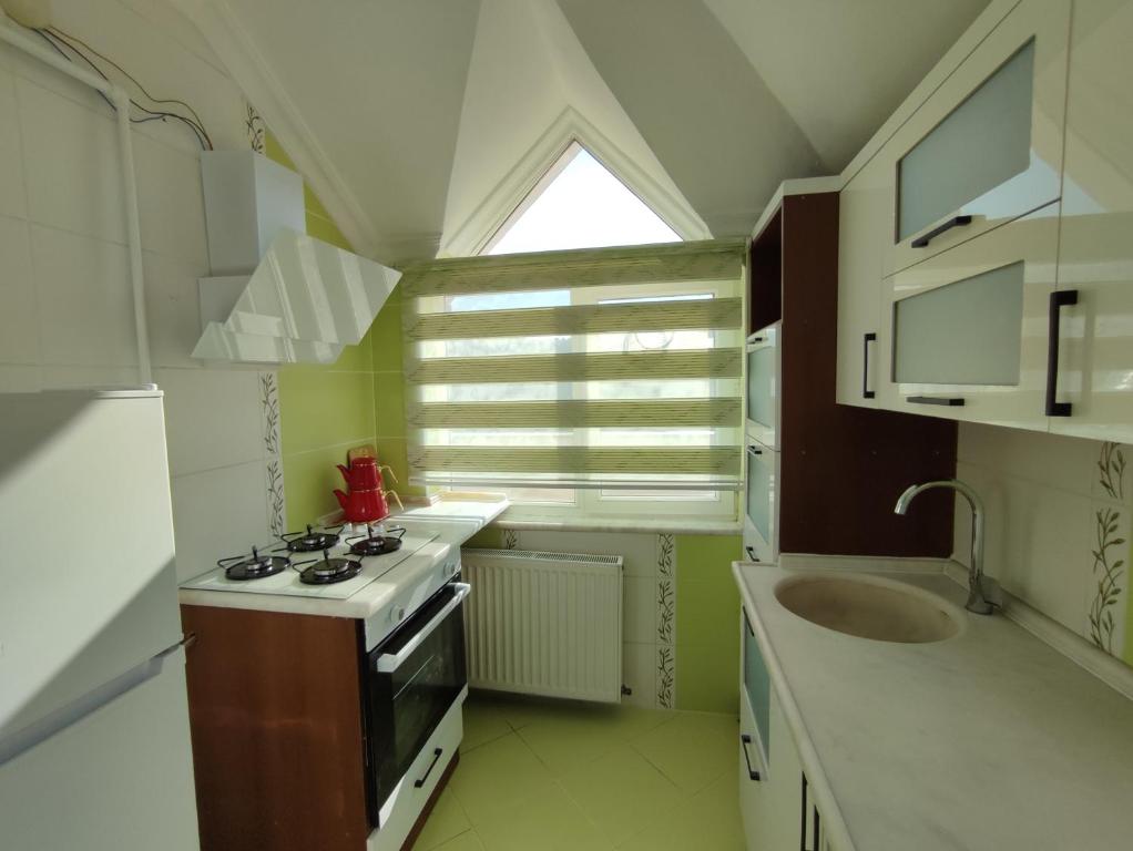 a kitchen with a stove and a sink and a window at Penthouse in Trabzon