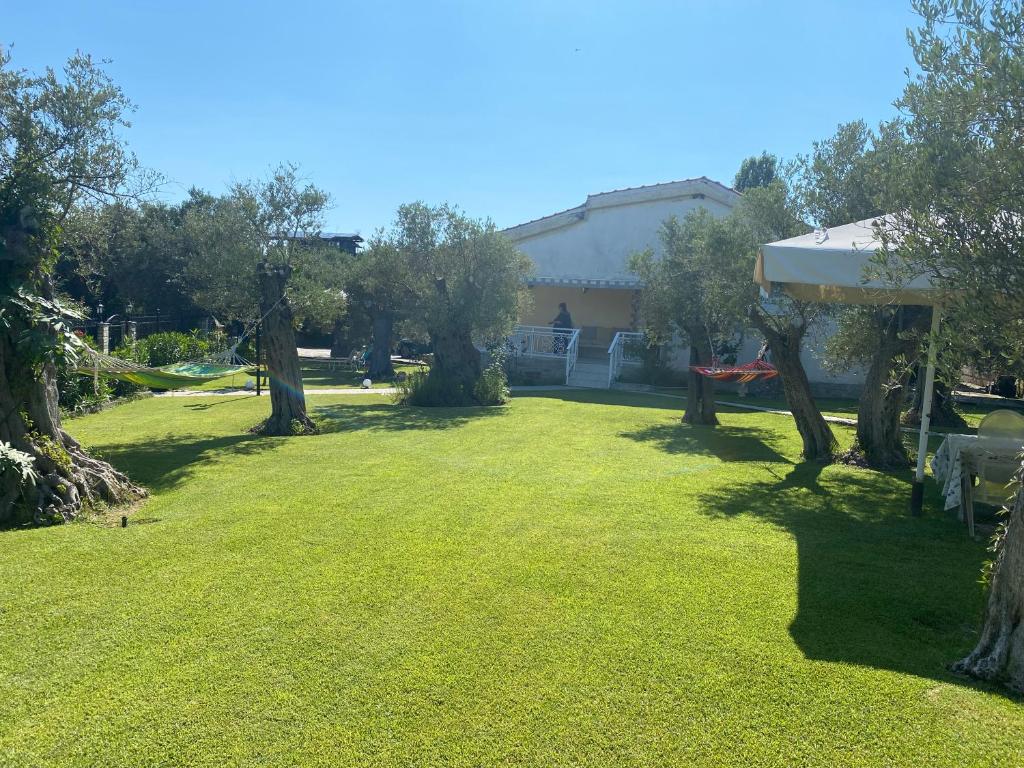 a yard with green grass and trees and a building at TERRY'S VILLA in Makri