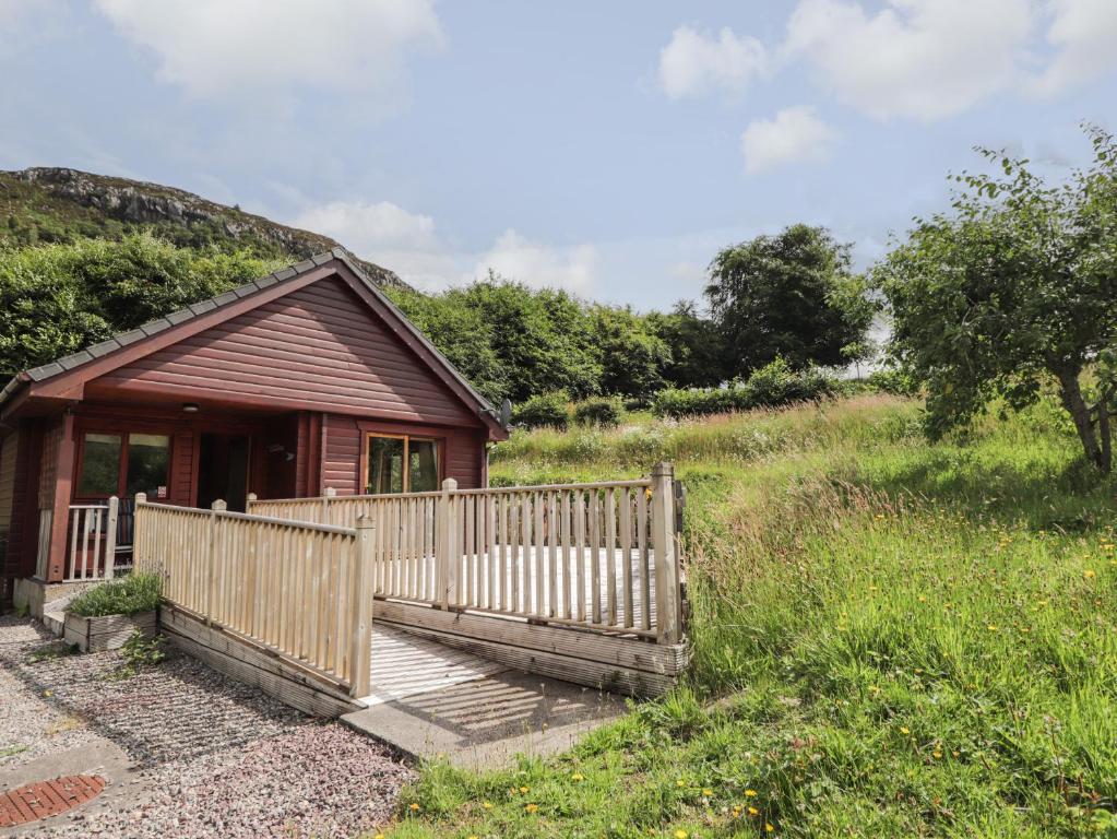 a small wooden cabin with a ramp leading to a porch at Dailfearn Chalet in Stromeferry