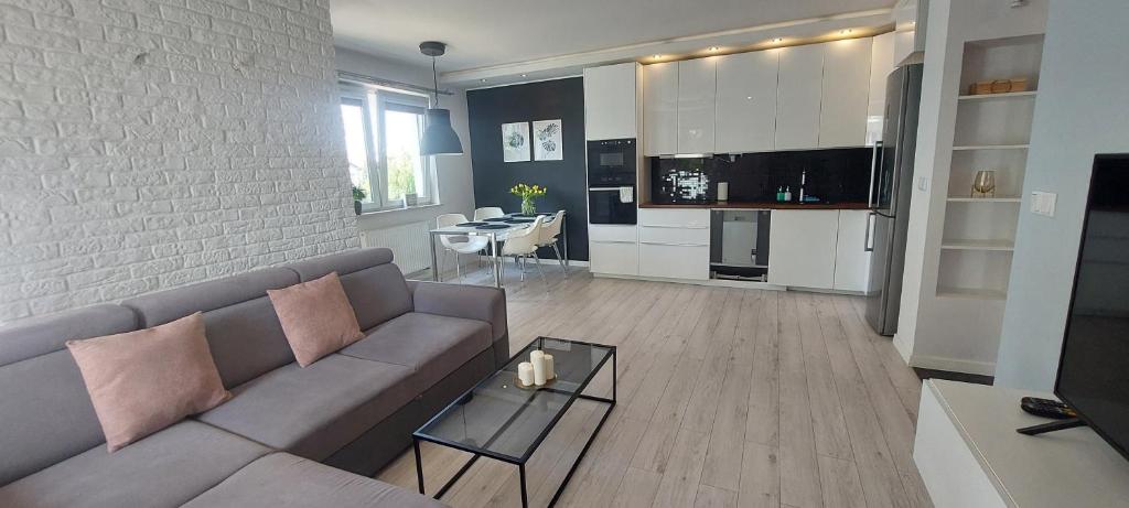 a living room with a couch and a dining room at Apartament Przymorze in Gdańsk