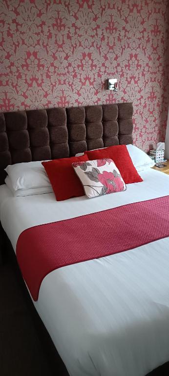a bedroom with a large bed with a red blanket at Lawnswood Guest House in Torquay
