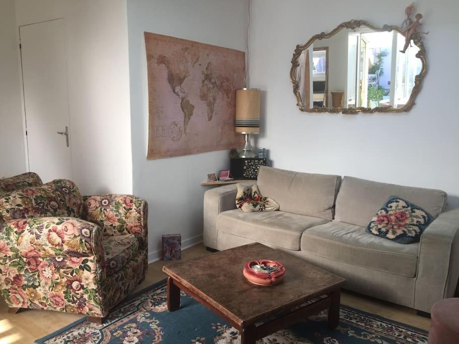 a living room with a couch and a table at La petite maison et ses quatre vélos in Rezé