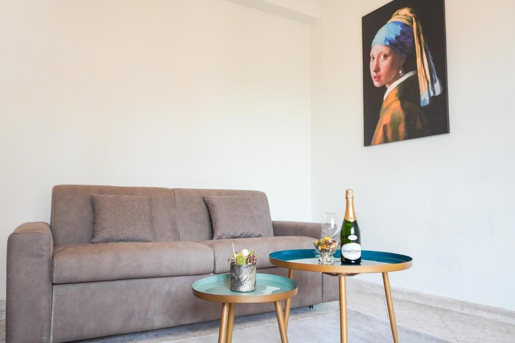 uma sala de estar com um sofá e duas mesas com um quadro em Fiera Apartment em Pero