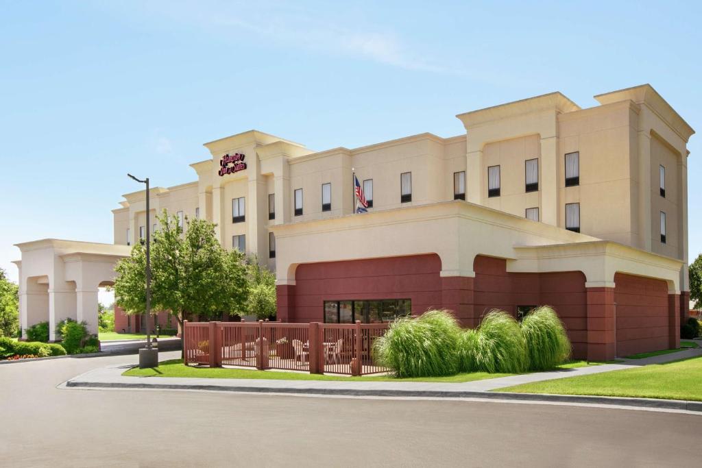 a building with a fence in front of it at Hampton Inn & Suites Lawton in Lawton