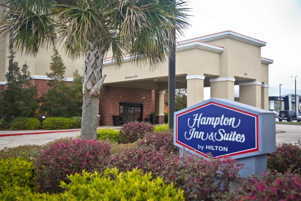 um sinal para a estalagem e suites em frente a um edifício em Hampton Inn & Suites Jennings em Jennings