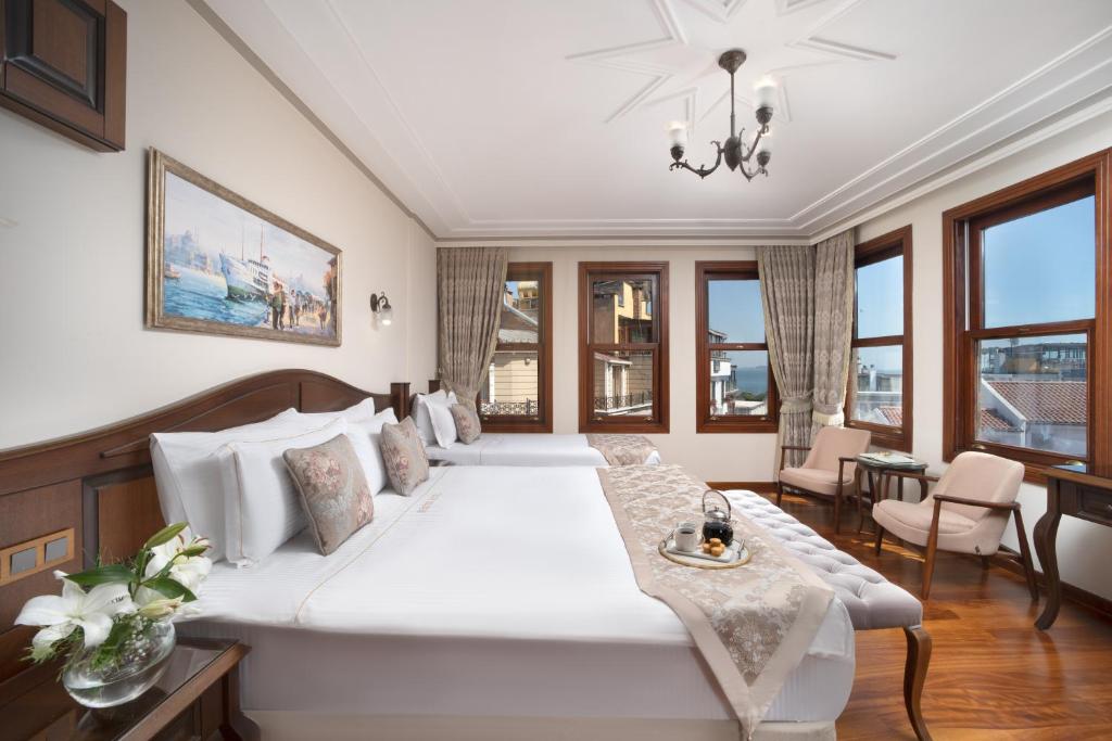Un dormitorio con una gran cama blanca y una mesa en Bender Hotel en Estambul