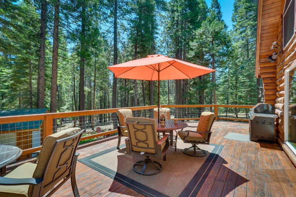 eine Terrasse mit einem Tisch, Stühlen und einem Sonnenschirm in der Unterkunft Lake Almanor Cabin with Deck and Beach Access in Westwood