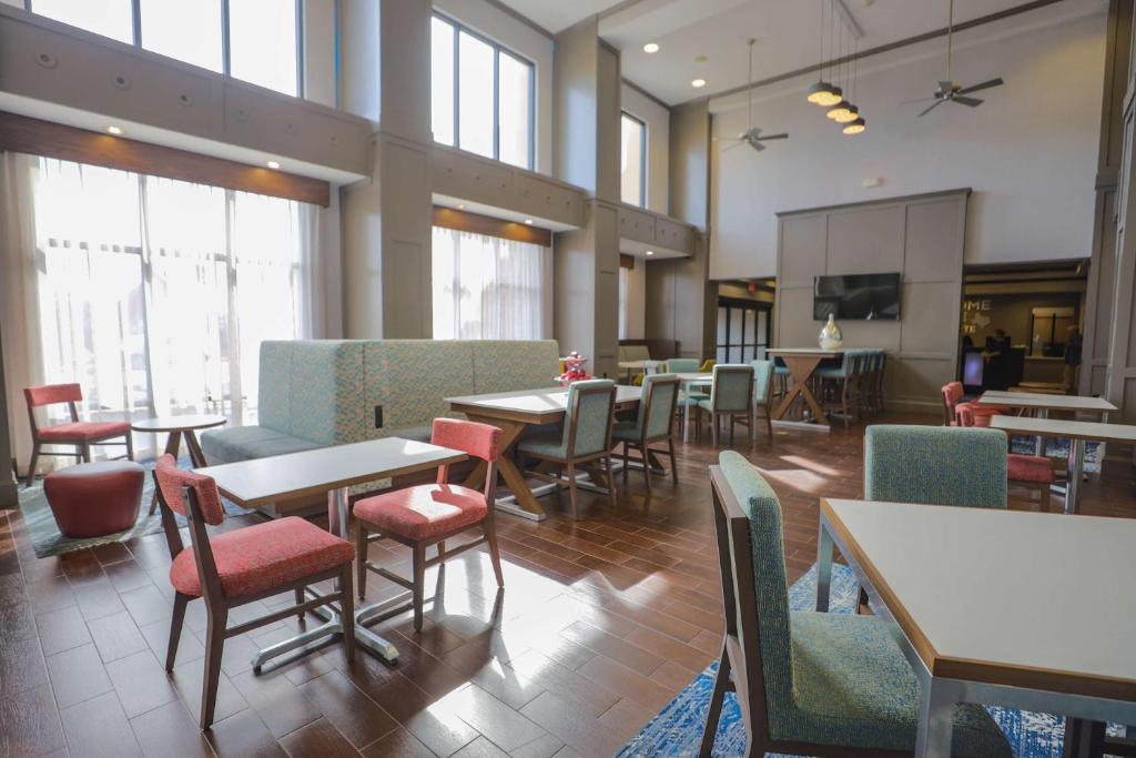 a dining room with tables and chairs and windows at Hampton Inn & Suites Bay City in Bay City