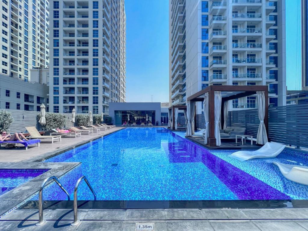a large swimming pool in a city with tall buildings at Exquisite 1 BDR apt in the heart of Dubai Marina- Studio One Tower in Dubai