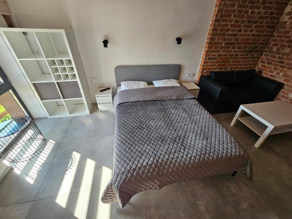 - une chambre avec deux lits, une chaise et un mur en briques dans l'établissement apartamentysienkiewicza11, à Bydgoszcz