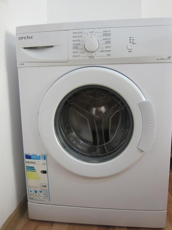 a white washing machine with its door open at Vila Gherghisan in Valu lui Traian
