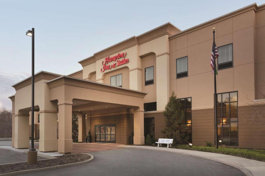 a hotel building with an american flag in front of it at Hampton Inn & Suites Mahwah in Mahwah