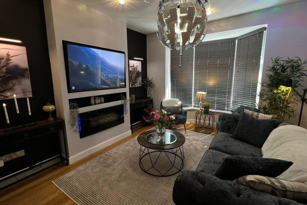 a living room with a couch and a flat screen tv at Stylish home close to Arena in Wincobank