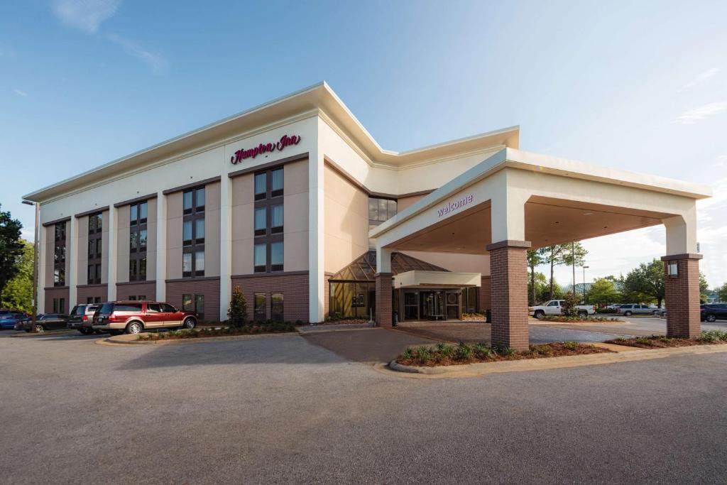 a hotel building with a car parked in a parking lot at Hampton Inn Meridian in Meridian