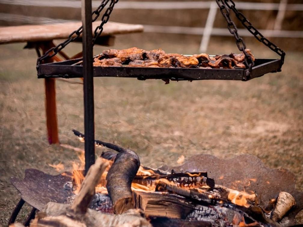 a tray of food is cooking over a fire at Agroturystyka Galant in Połęczyno