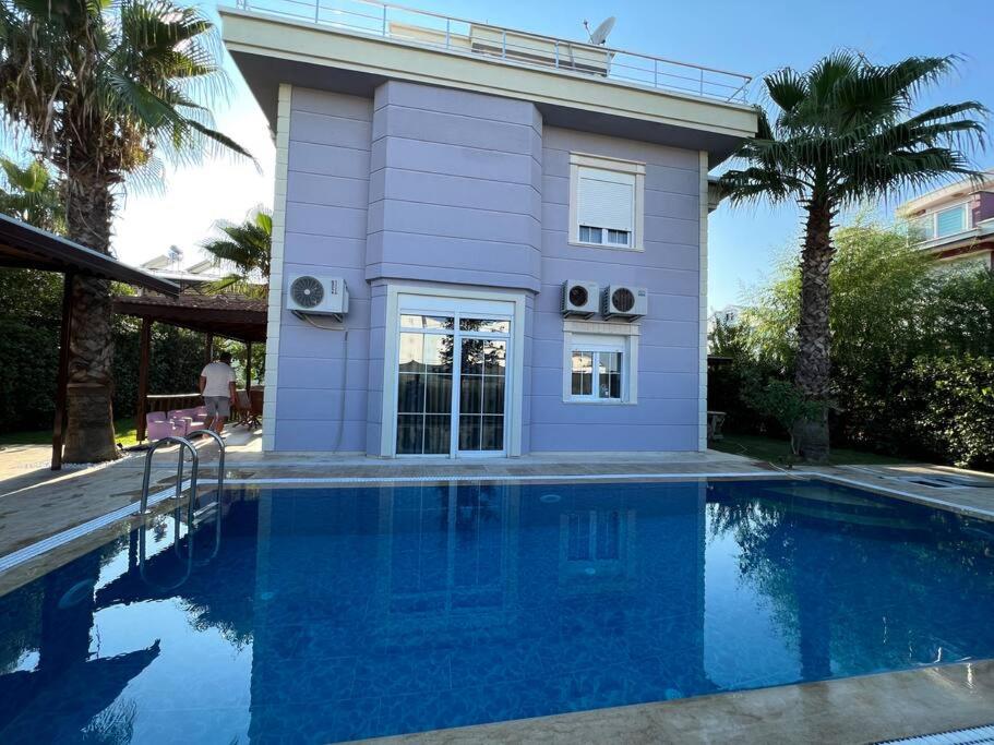 a house with a swimming pool in front of a house at Villa ateş in Belek