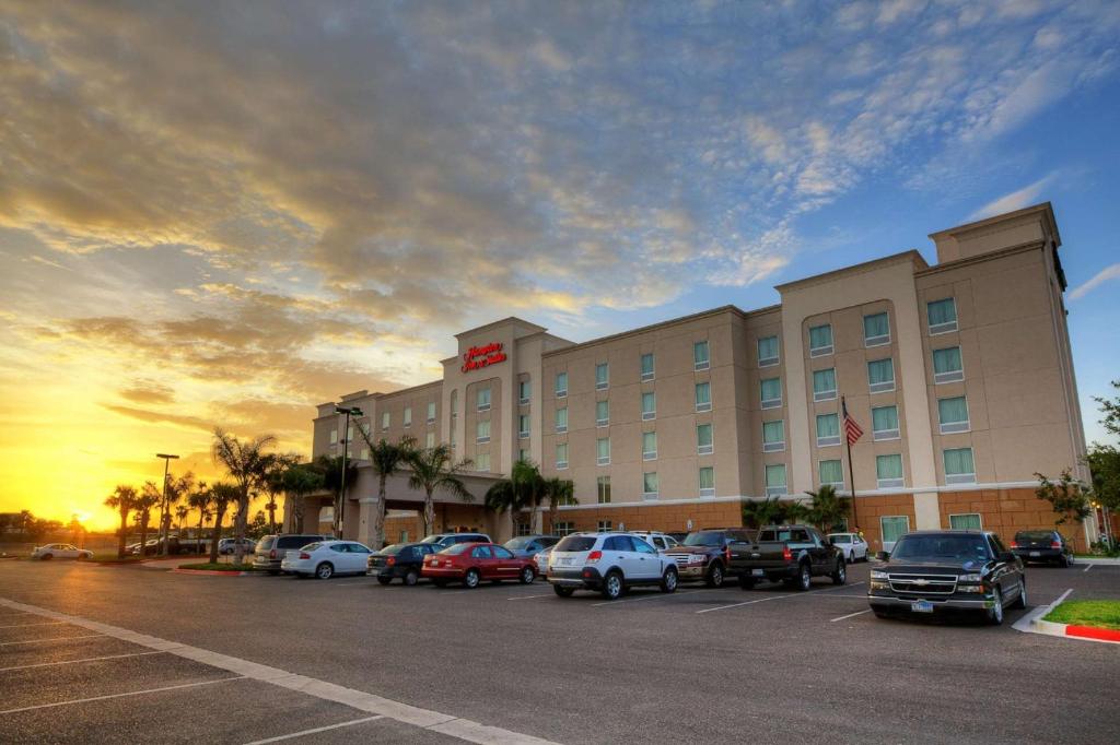un hotel con coches estacionados en un estacionamiento en Hampton Inn & Suites McAllen, en McAllen