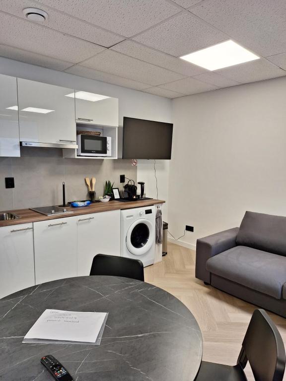 een keuken en een woonkamer met een tafel en een bank bij Perfect studio 14H center Rotterdam in Rotterdam
