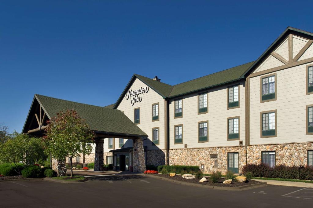 a large tan building with a black roof at Hampton Inn Kansas City The Legends in Kansas City