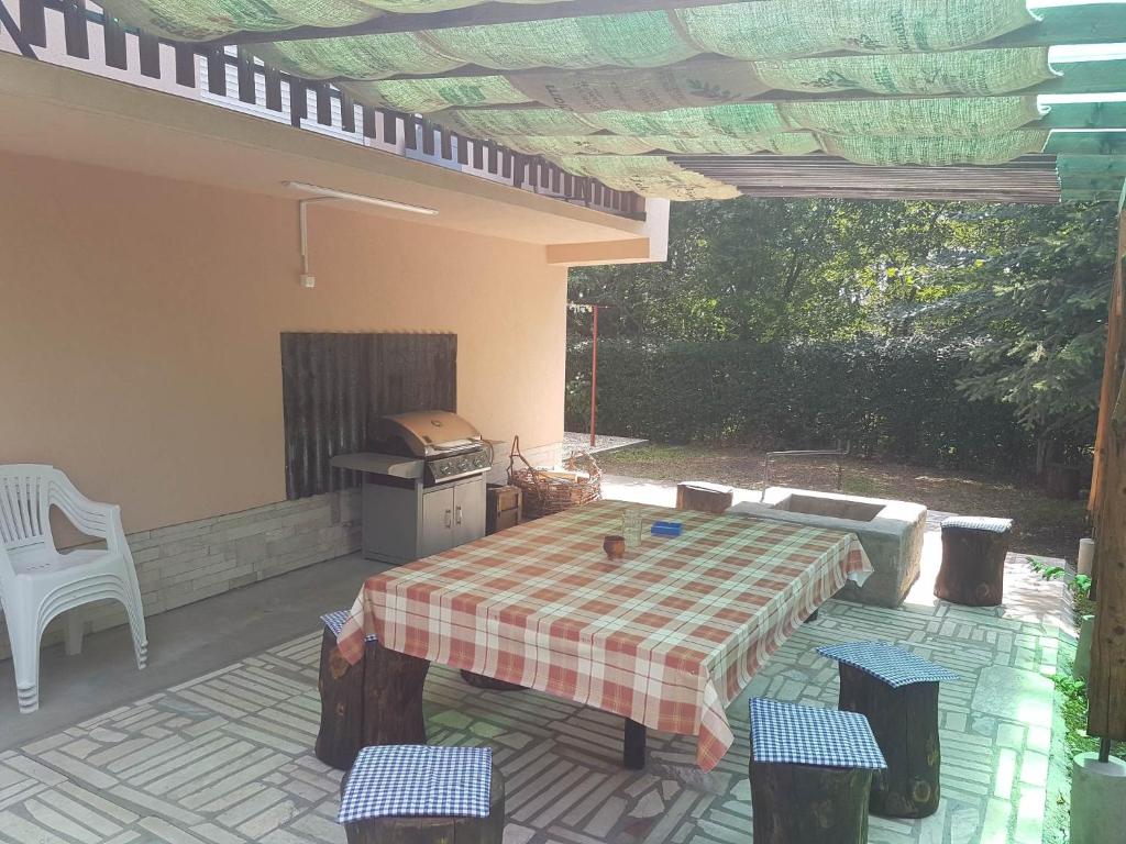 un patio con mesa, sillas y parrilla en Hármas Apartman - Zsóryfürdő Mezőkövesd en Szihalom
