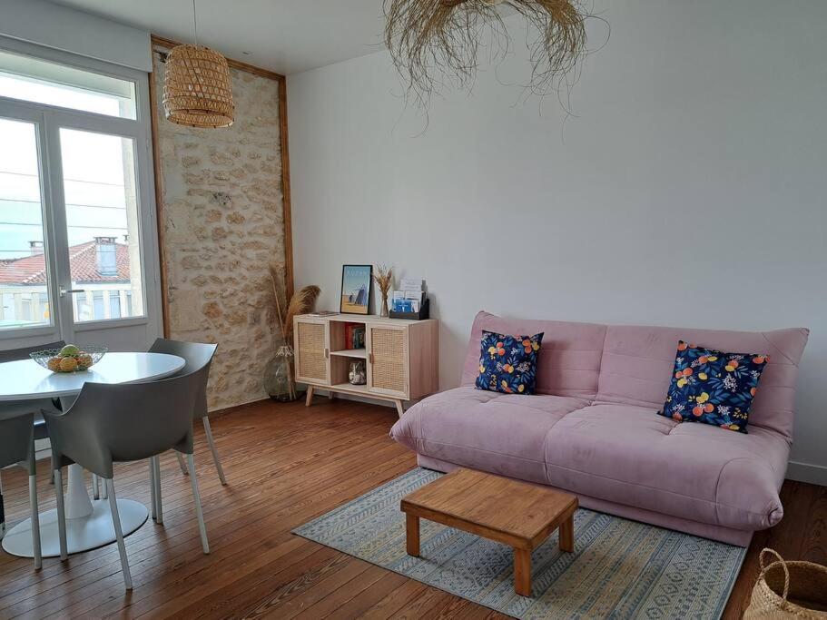 a living room with a purple couch and a table at Appartement, Royan. Proche plage. in Royan