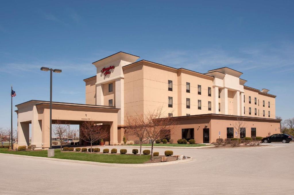 a large white building with a clock on top of it at Hampton Inn Macomb in Macomb