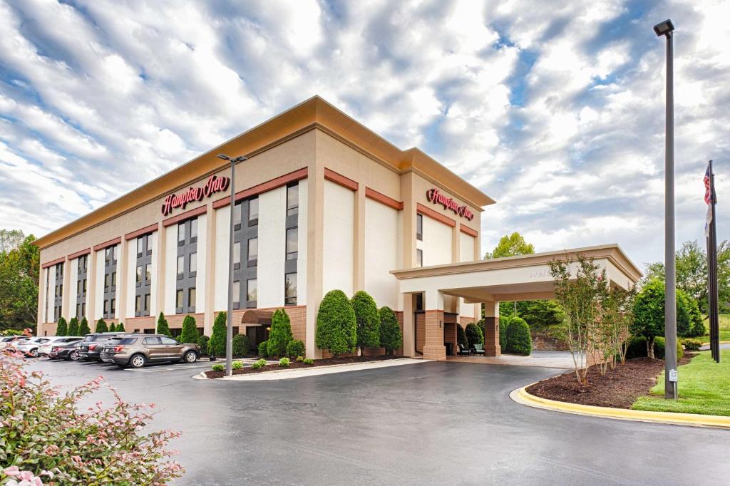 un hotel di fronte a un parcheggio con auto parcheggiate di Hampton Inn Morganton a Morganton