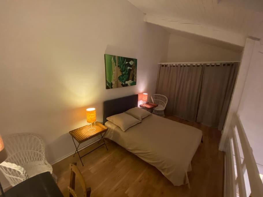 a small bedroom with a bed and two lamps at - Appartement Cauris - in Vieux-Boucau-les-Bains