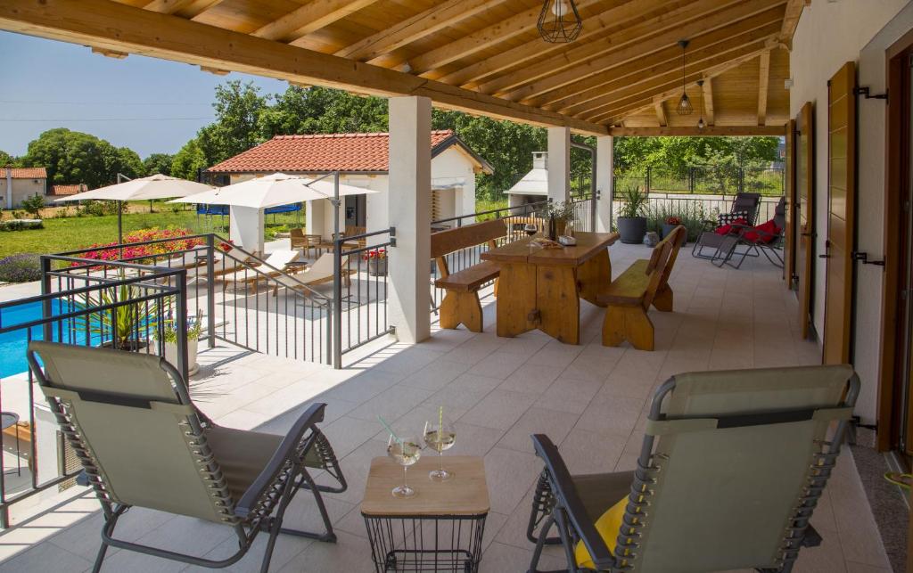 patio z krzesłami i stołem oraz basenem w obiekcie Kuća Roža - Dolinci w mieście Sveti Petar u Šumi