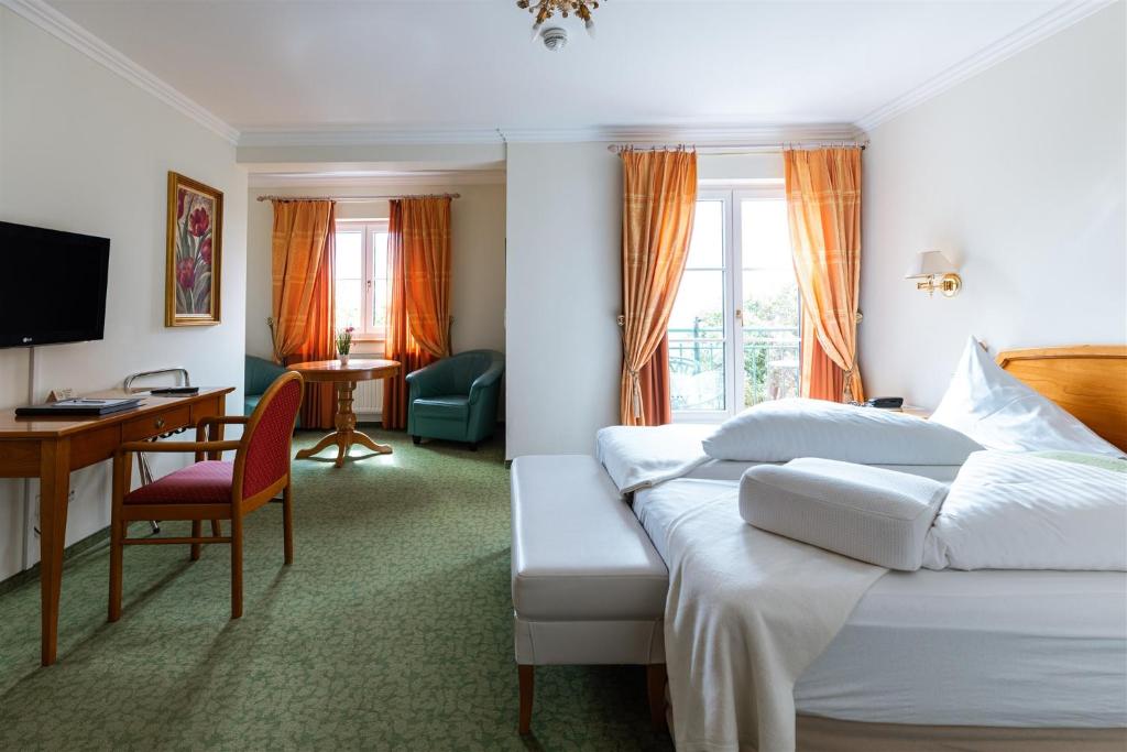 a hotel room with a bed and a desk at Kurhaus Dr. Petershofer in Wolfsegg am Hausruck