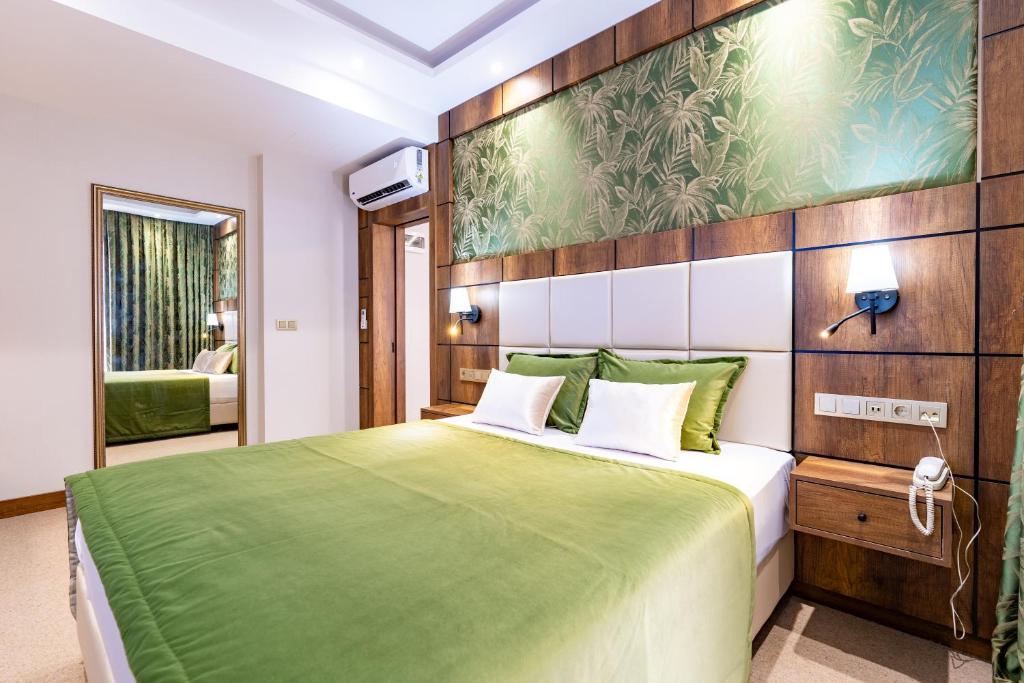a bedroom with a bed with a green blanket at Mardy Hotel in Istanbul
