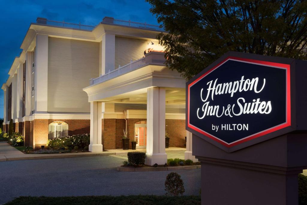 um sinal para a estalagem e suites em frente a um edifício em Hampton Inn & Suites Middletown em Middletown