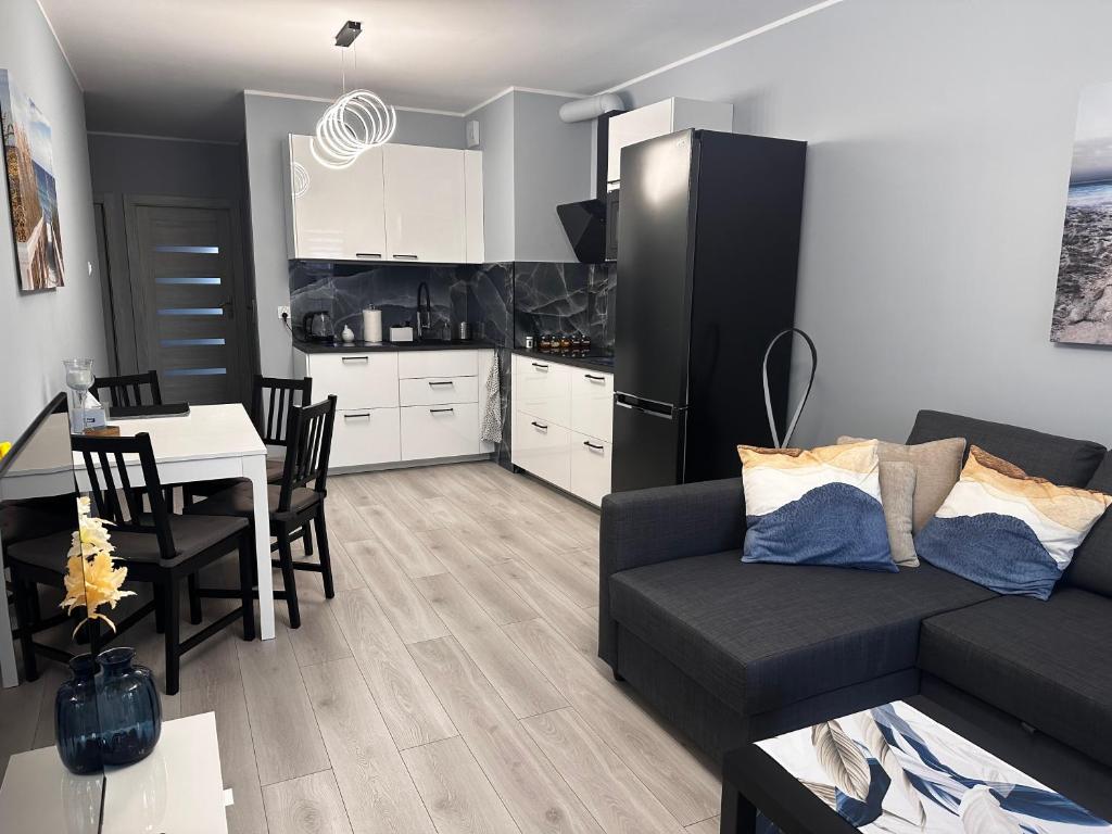 un soggiorno con divano e tavolo e una cucina di Blue and Cozy Apartment - Baltea Apartments a Danzica