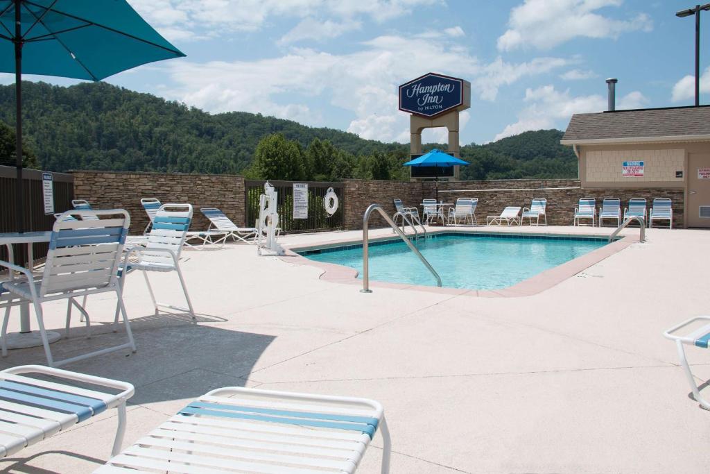 a swimming pool with lounge chairs and a hotel at Hampton Inn Murphy in Murphy